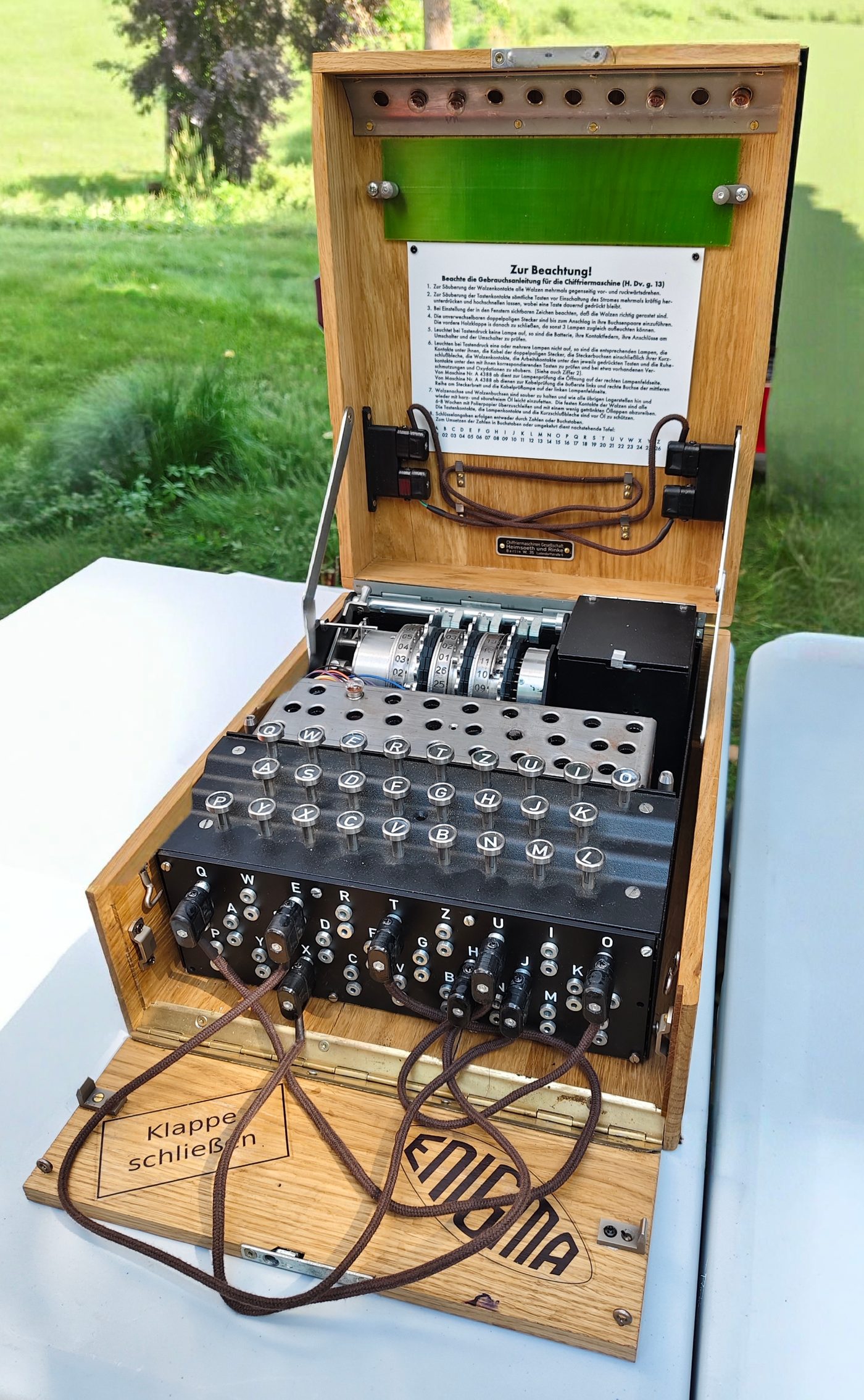 Figure 4 — A commercial-pattern Enigma cipher machine of the type that descends from Scherbius's 1920s glowlamp models, with its three rotors set into the top above the lamp panel and keyboard. Pho…